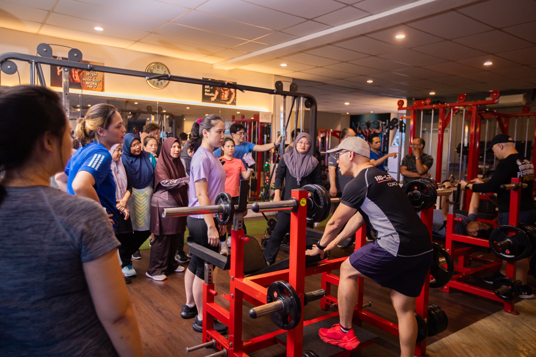 Coach Ho leading a group resistance-training session in the gym