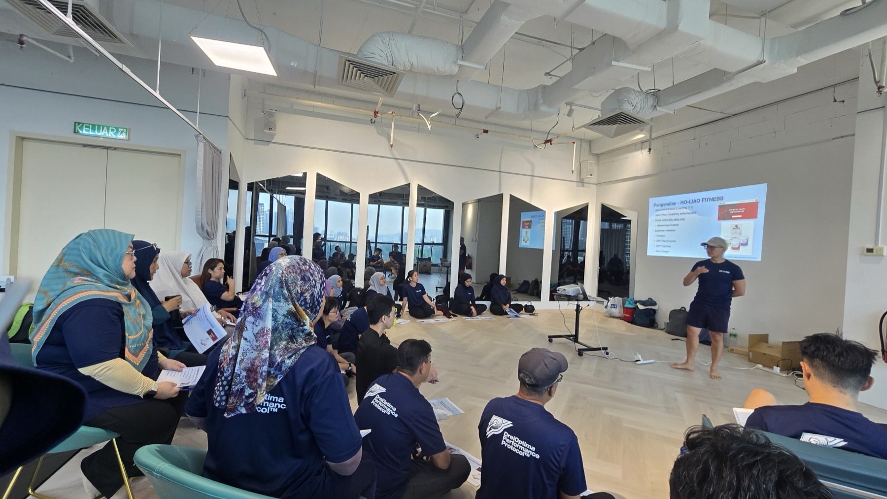 Coach Ho leading a seated learning session in a studio
